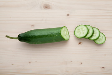 One Cucumber on a wooden background.