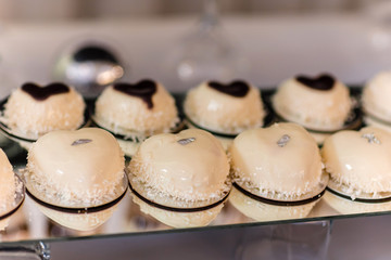 candy bar. Fashionable mousse cake with white mirror glaze and chokolate with coconut flakes. Modern dessert.