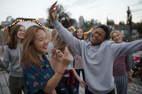 Playful teenagers dancing at movie in the park