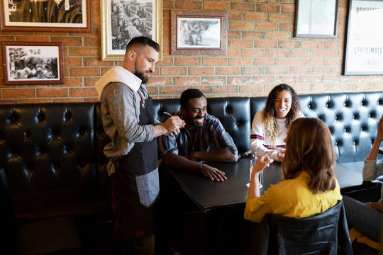 Waiter Taking Order From Friends In Bar