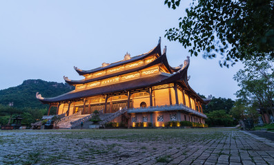 Fototapeta premium Ninh Binh, Vietnam - May 2019: sunset view over The Buddhas of The Three Times Hall