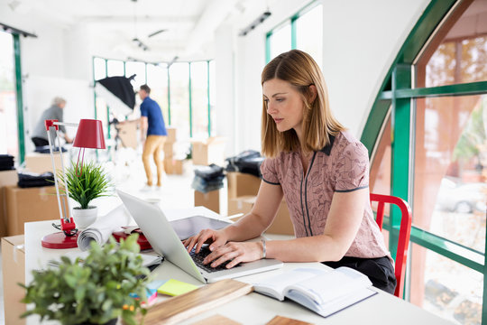 Businesswoman Working At Laptop In New Office Space