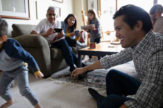 Latinx Multi-generation Family Playing In Living Room