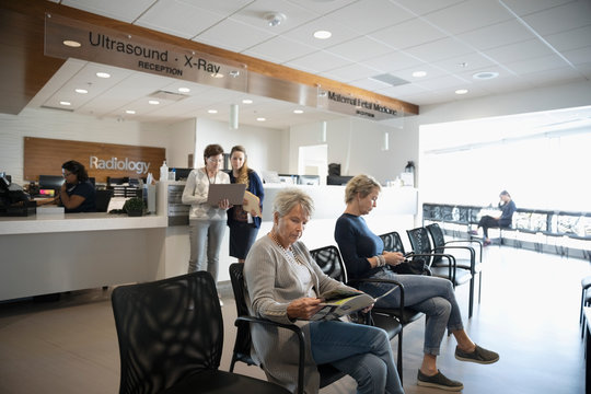 Senior Woman Reading Brochure, Waiting In Clinic Waiting Room