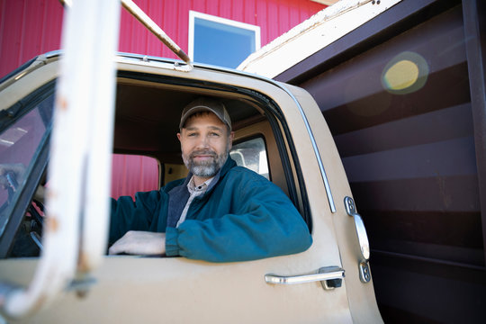 Portrait confident male farmer driving truck