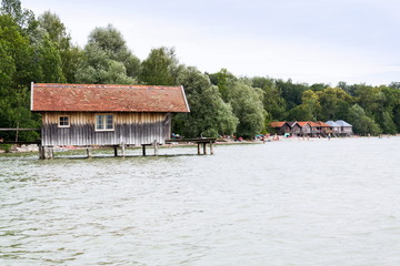 Obraz premium Wooden cottage on pier on the lake Ammersee in Inning am Ammersee, Germany