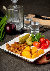 Assorted pickled and fresh vegetables - pickled herring, chopped chives with potato, peppers, cucumbers, tomatoes, capers, salt and herbs. Set of vegetables snacks for alcohol vodka. Russian cuisine