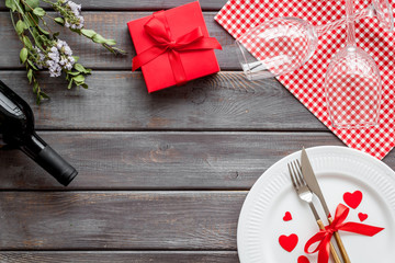 Valentines day table. Plate and wine on dark wooden background top-down copy space