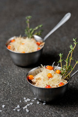 Festive french julienne with sea buckthorn in a bowl on black stone background. Rustic style. Close up, selective focus.