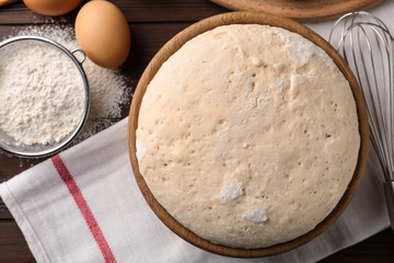 Bowl with dough for pastries on table, flat lay
