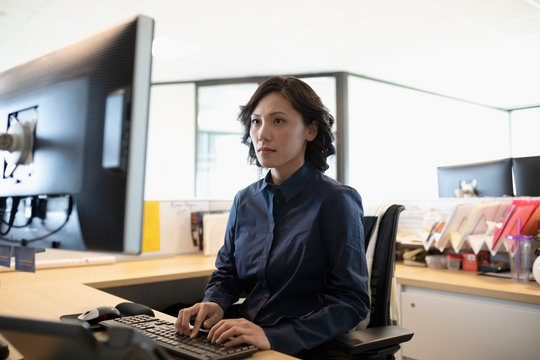 Focused Businesswoman Working At Computer In Office