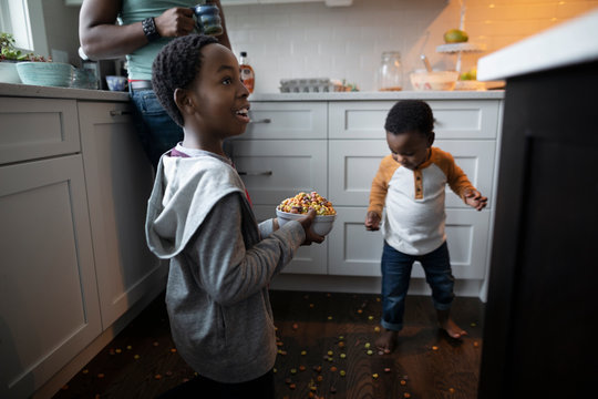 Playful Brothers Spilling Cereal On Kitchen Floor