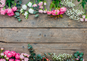 Frame of flowers on craft wooden background