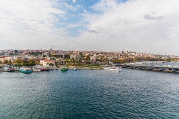Fototapeta premium Tourist ship sails on the Golden Horn, Istanbul, Turkey. Scenic sunny panorama of Istanbul city in summer. Beautiful waterfront of Istanbul at sunset. Concept of traveling and vacation in Istanbul.