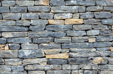 Wall masonry finishing from colorful natural stone trim as background front view closeup