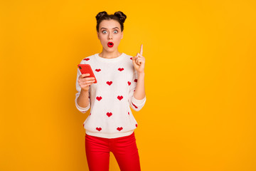 Photo of pretty lady hold telephone hands raise index finger open mouth clever person have idea wear hearts pattern white pullover red trousers isolated yellow color background