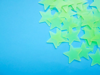 green stars on a blue background. stars glowing in the dark, place for text