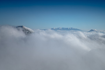 Clouds in winter mountains. Landscape photo, edit space