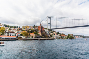 Obraz premium Tourist ship sails on the Golden Horn, Istanbul, Turkey. Scenic sunny panorama of Istanbul city in summer. Beautiful waterfront of Istanbul at sunset. Concept of traveling and vacation in Istanbul.