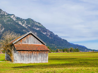 Fototapeta na wymiar Holzscheune auf Herbstwiese Alpen
