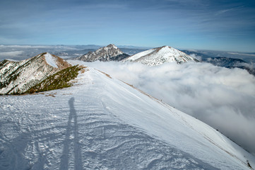 Tourist standing in winter mountains. Snowy hills in background. Mala Fatra, Slovakia