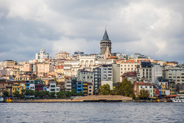 Fototapeta premium Tourist ship sails on the Golden Horn, Istanbul, Turkey. Scenic sunny panorama of Istanbul city in summer. Beautiful waterfront of Istanbul at sunset. Concept of traveling and vacation in Istanbul.