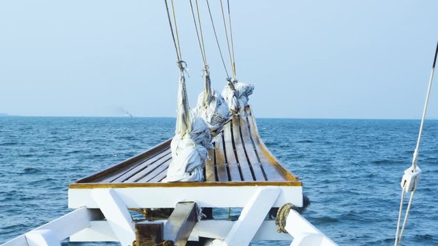 Wooden boat is moving forward on blue ocean