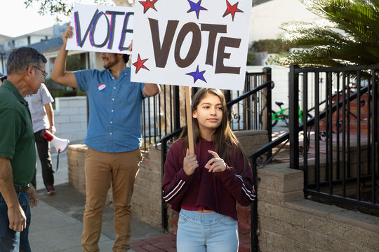 Latinx tween girl volunteering, canvassing voters