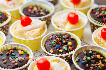 Muffin cupcakes sprinkled with crushed cookies. Cherry on top.