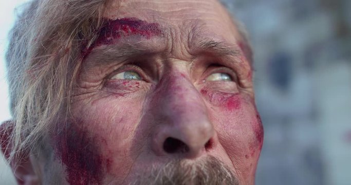 Old, wounded cossack with mustache thinks and looks at camera with sad eyes