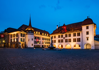 Picturesque nightscape of illuminated buildings and town hall of Thun, Switzerland