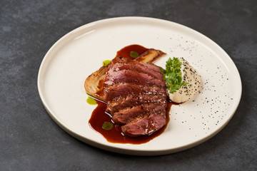 Baked turkey Fillet with Celery Puree and sauce on white plate