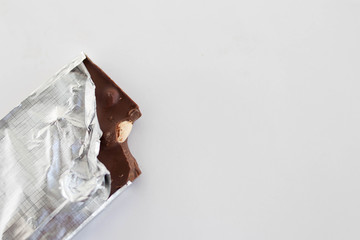 Chocolate with nuts in foil on a white background