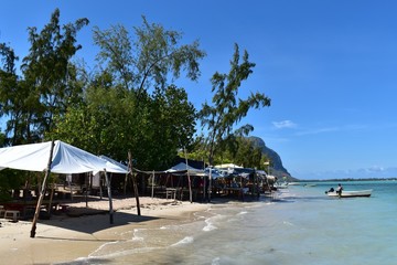 Tropical beach with traditional shelters where you can enjoy food and drinks in the shade of the sun.