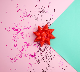 red bow and shiny multicolored round confetti scattered