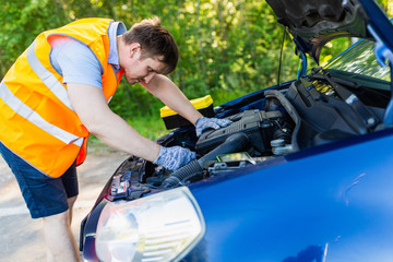 The mechanic fixes the car engine with a special key. Hands mechanic with a wrench tighten the bolts.