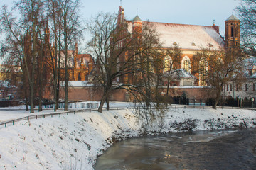 Fototapeta na wymiar View of the Church of St. Francis and Bernard near the river Vilnia in the Old Town of Vilnius in winter. Lithuania