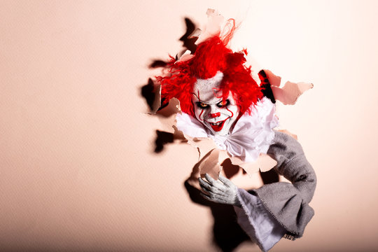 scary clown killer breaks through the wall. horror. Halloween concept.