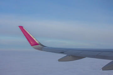 Passenger airplane wing in the sky in clouds.