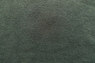 Surface of dark green jersey fabric from above