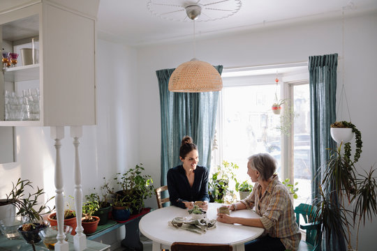 Women Drinking Coffee At Kitchen Table