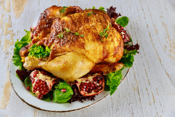 Roasted turkey on plate with herbs and pomegranate.