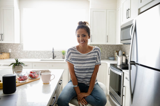Portrait confident woman drinking coffee in morning kitchen