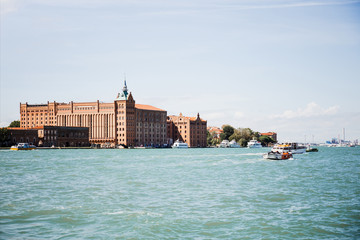 view of floating motor boats near ancient buildings in Venice, Italy