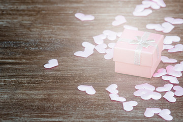 Gift box with hearts on a wooden background. Valentine`s day.