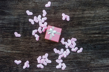 Gift box with hearts on a wooden background. Valentine`s day.