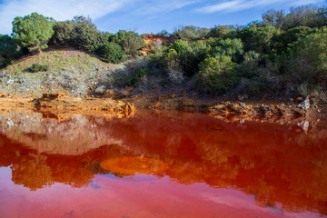 Pollution in the red lake 'Le Conche' on Elba island. Italy