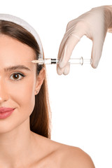 Fototapeta premium Young woman receiving filler injection against white background