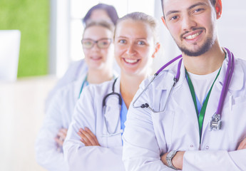 Happy medical team comprising male and female doctors smiling broadly and giving a thumbs up of success and hope