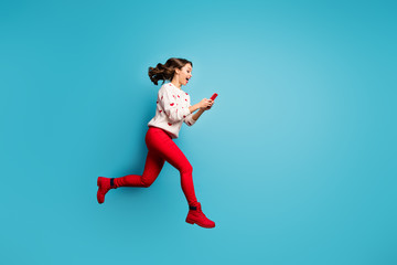 Fototapeta na wymiar Full length body size view of her she nice attractive cheerful cheery glad girl jumping having fun using 5g app running fast hurry rush isolated on bright vivid shine vibrant blue color background